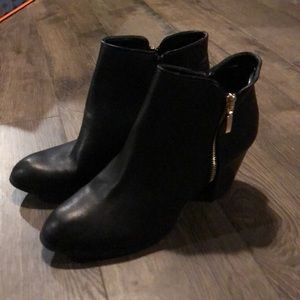 Black heel booties with gold zipper detail